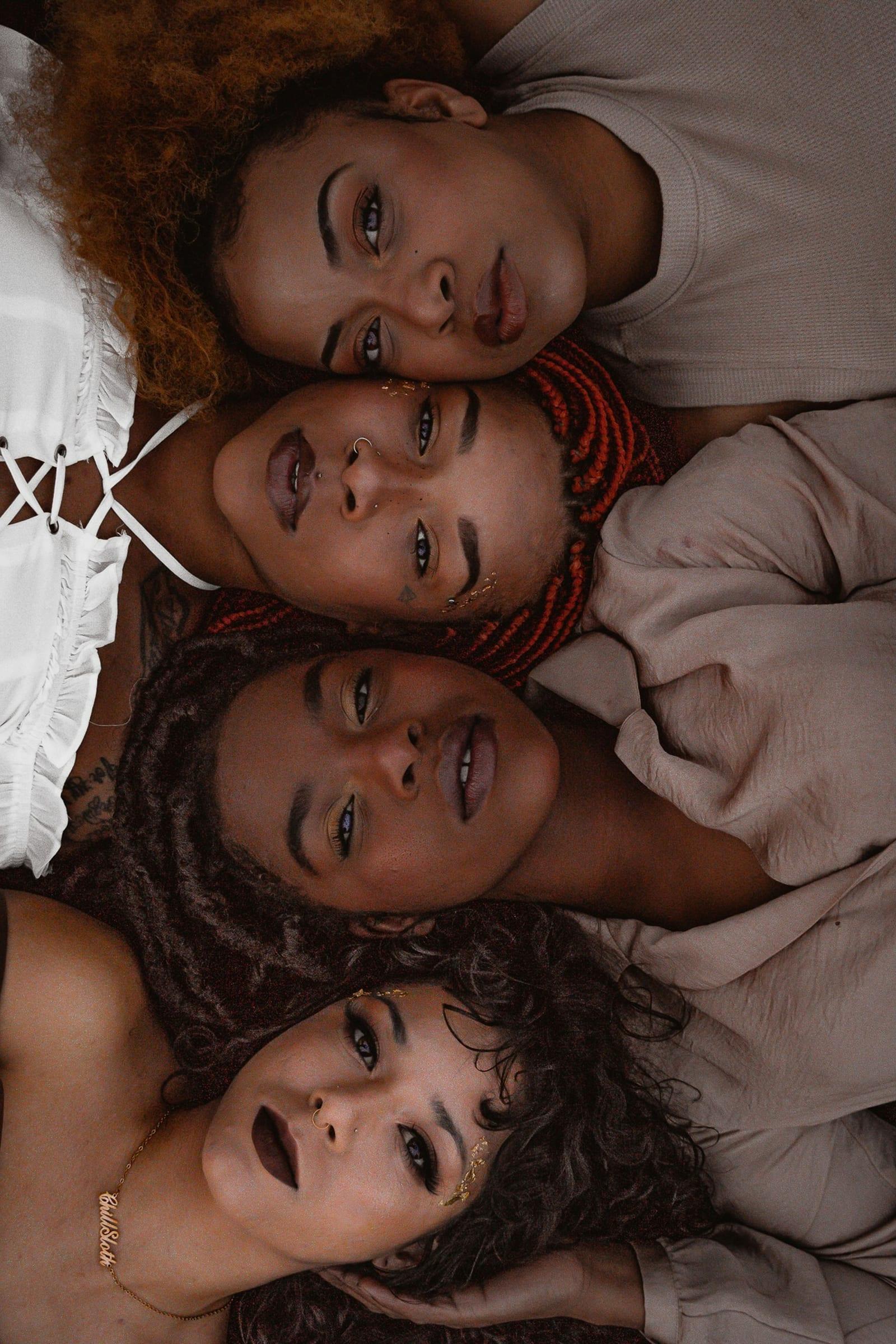 Four women photographed in a close stacked frame, looking directly at camera.